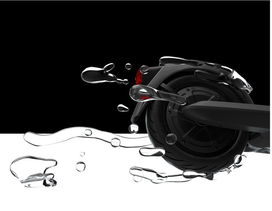 Rear wheel of the Segway Ninebot E2 Pro electric scooter splashing through water