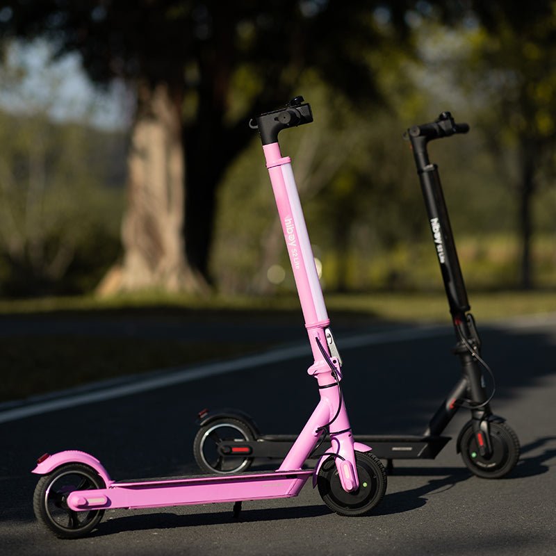Pink and black Hiboy S2 Lite electric scooters parked on a park path