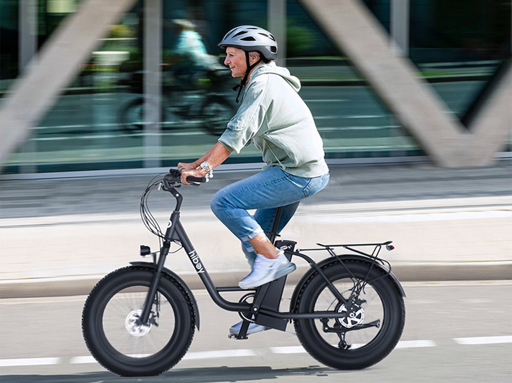 Rider on the Hiboy EX6 electric bike passing an office building at speed