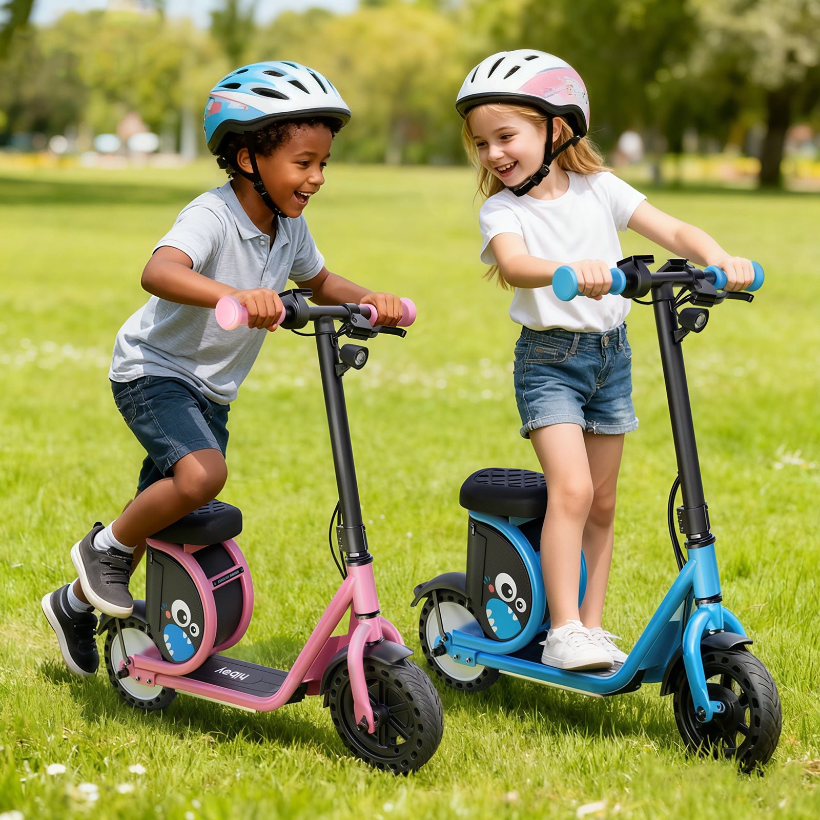 Two children laughing on pink and blue Hiboy Joy Haul kids electric scooters in a park