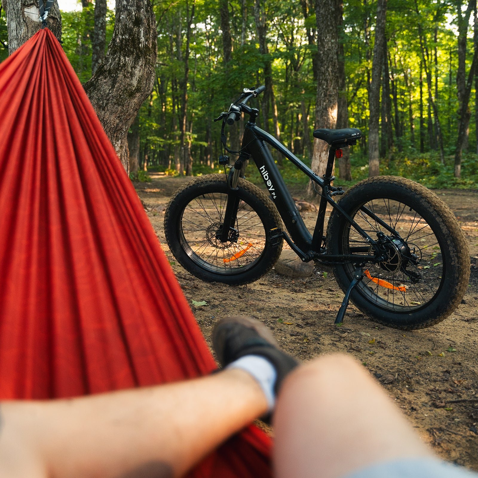 Hiboy P6 fat tire electric bike parked in the woods seen from a red hammock