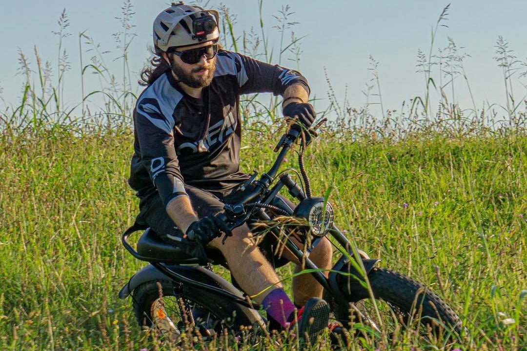Rider on the Riding’times Z8 Pro electric bike in tall grass