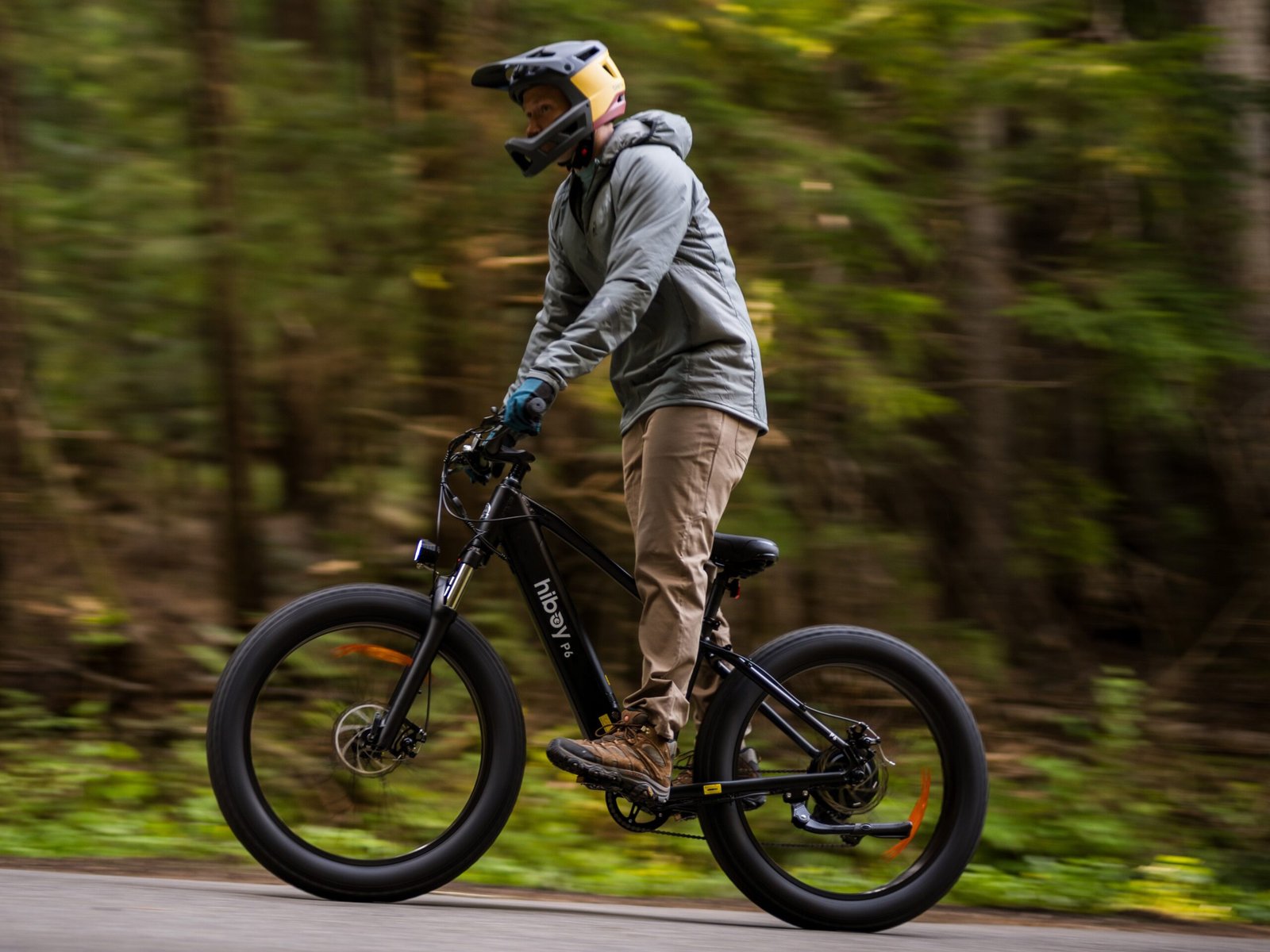 Rider on a Hiboy P6 fat tire electric bike moving fast along a forest road