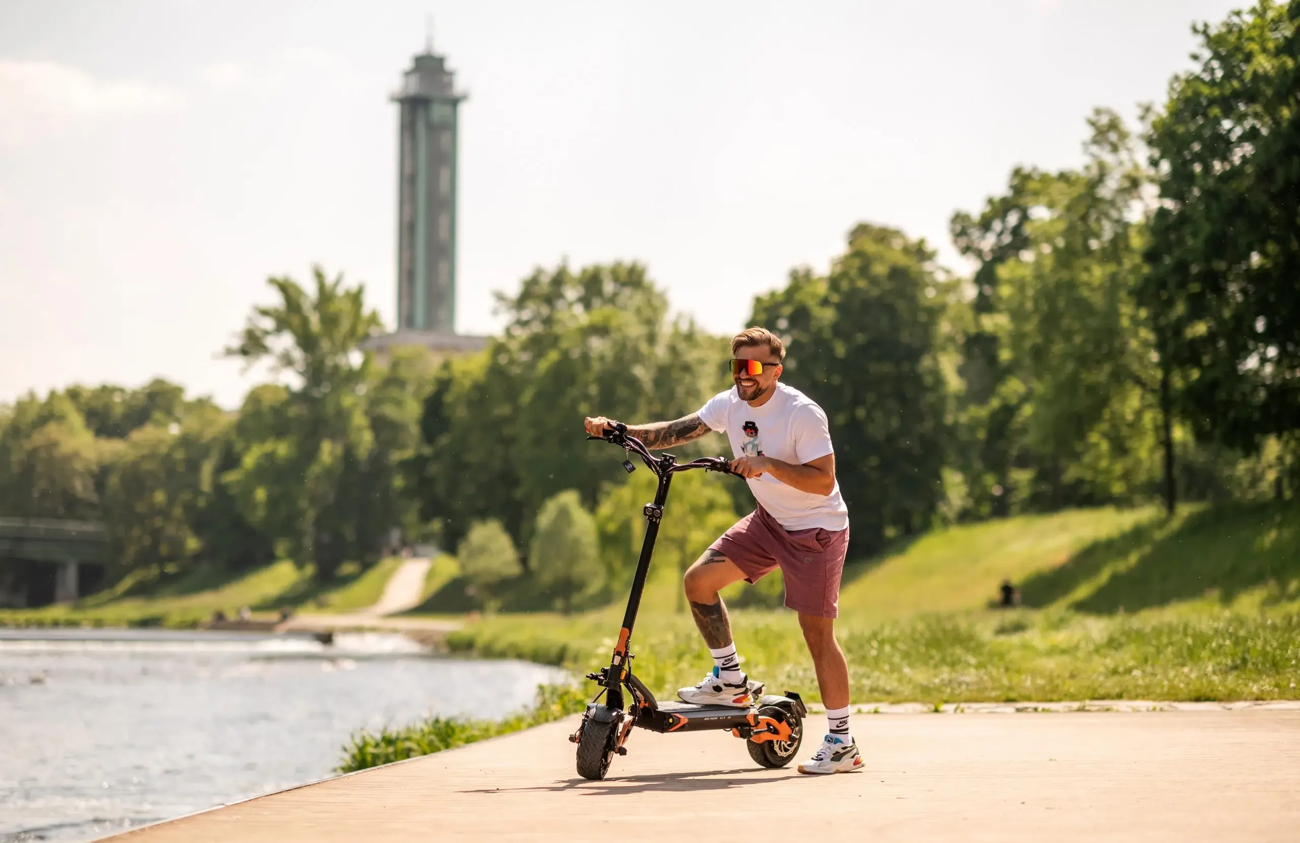 Rider leaning on the Teverun Blade GT II+ electric scooter by the river