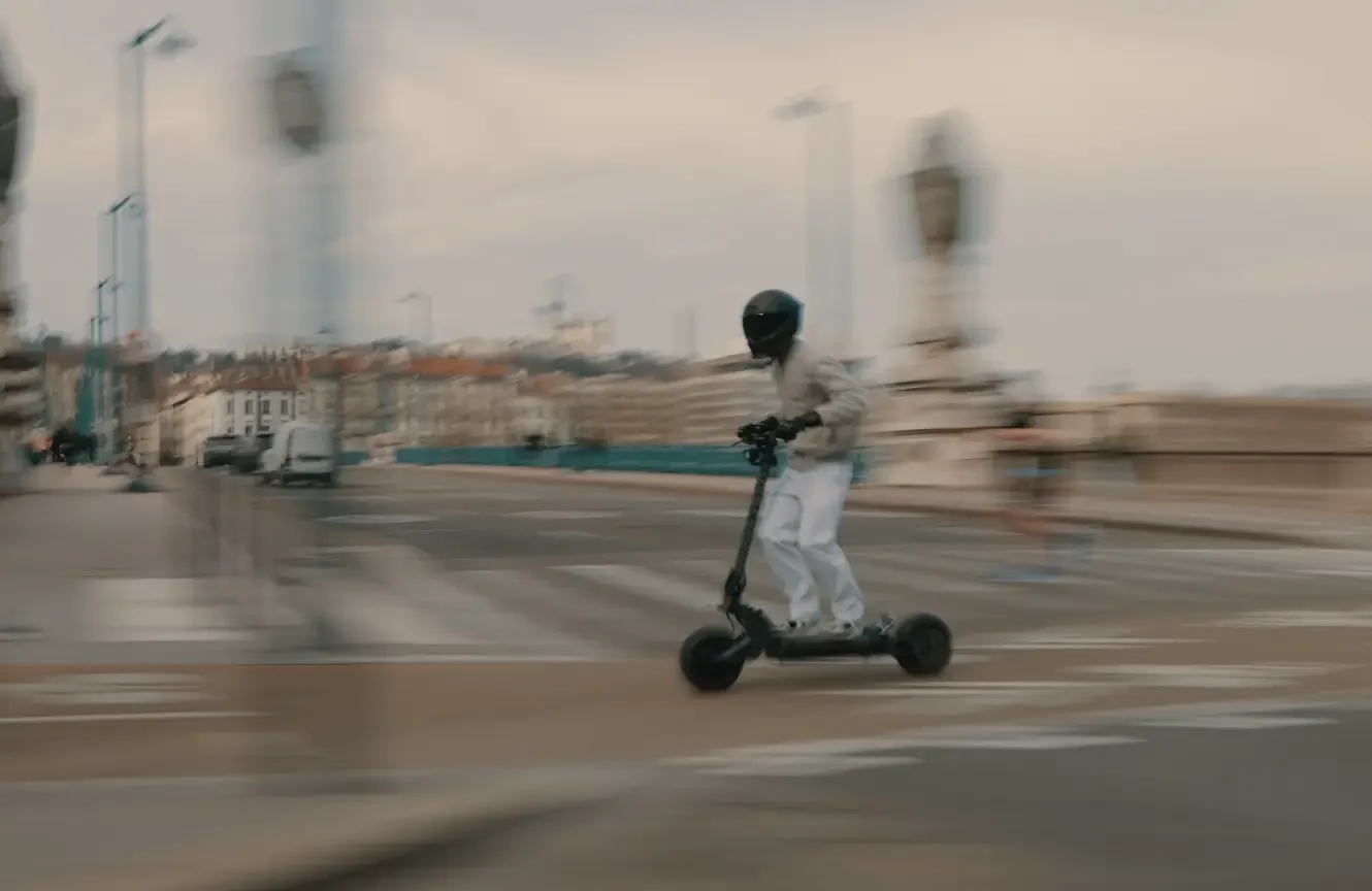 Rider on the Teverun Fighter Supreme 7260R electric scooter crossing a city bridge